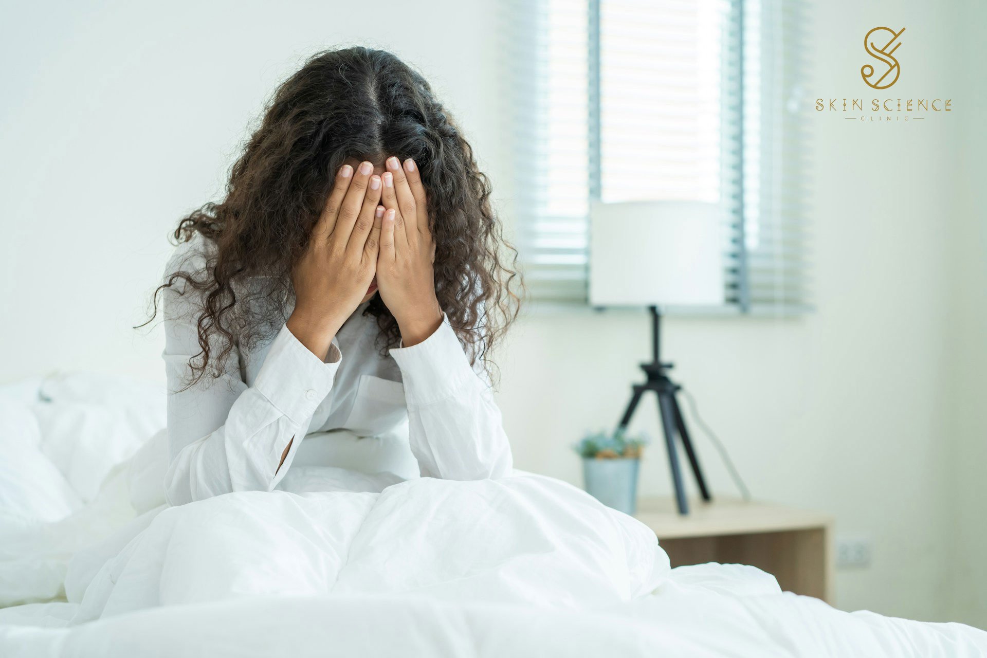 A woman lying down with a migraine