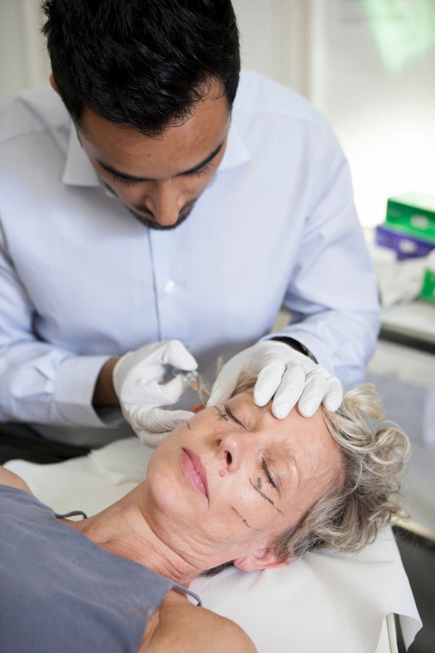 Dr Sarwar injecting dermal filler into a female patient's cheek