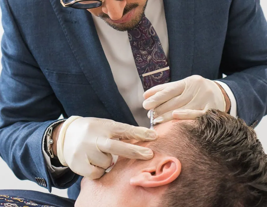 Dr Adil Sarwar injecting temple fillers on a young male patient