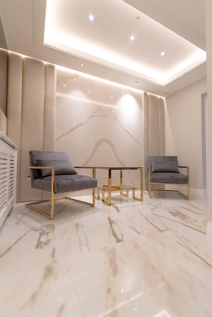 The marble sitting area at Skin Science Clinic, with gold-framed armchairs